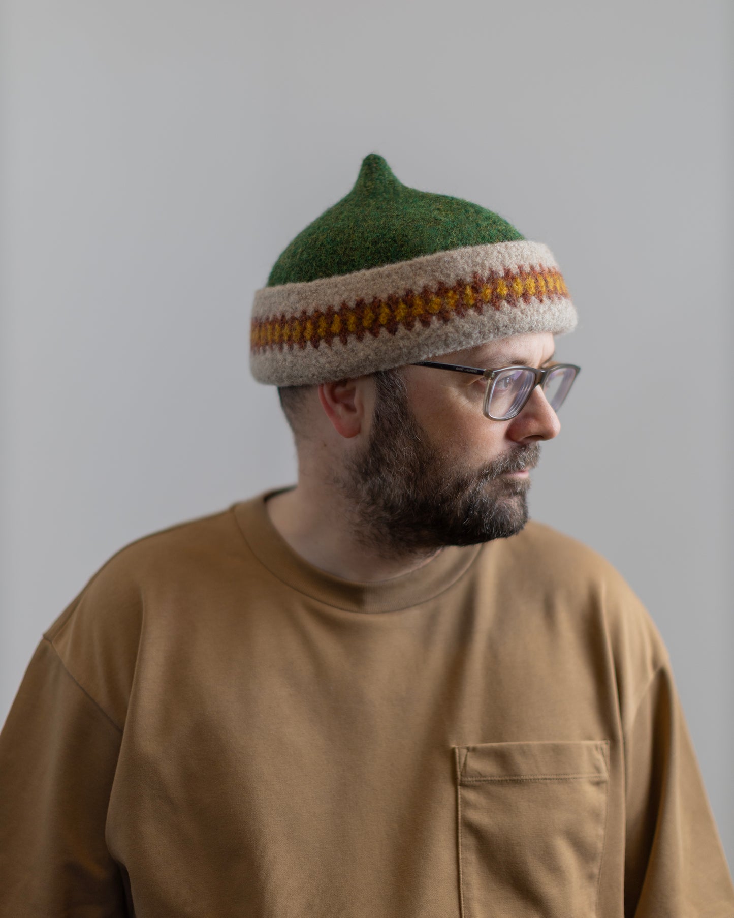 Orange patterned edge and green top woollen hat