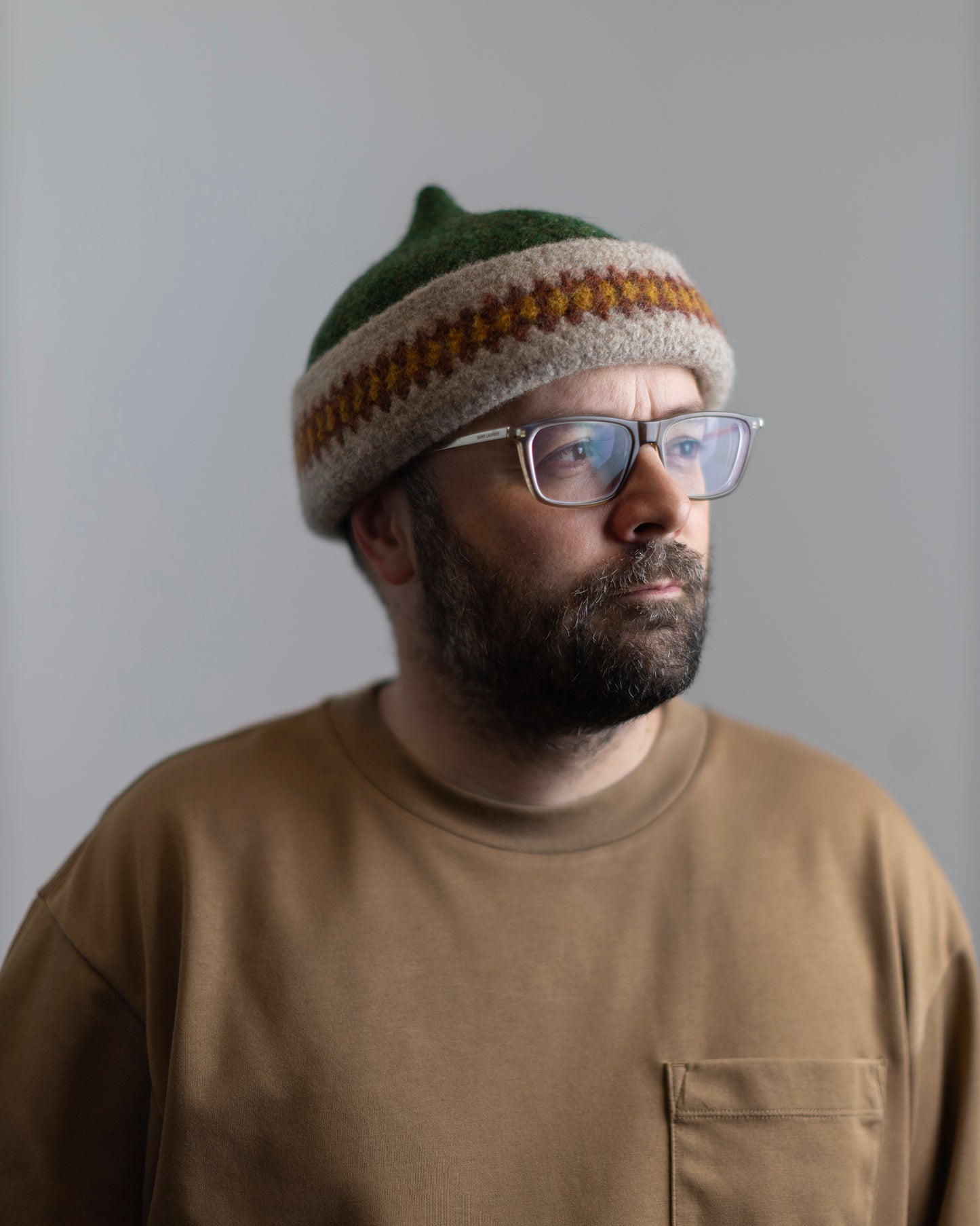 Orange patterned edge and green top woollen hat